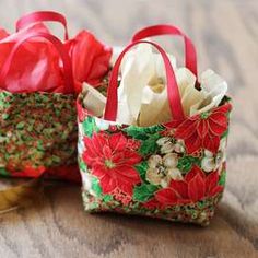 two small bags with red bows on them sitting on a table next to each other