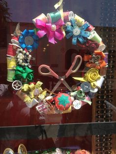 a pair of scissors sitting on top of a pile of hair accessories in front of a window