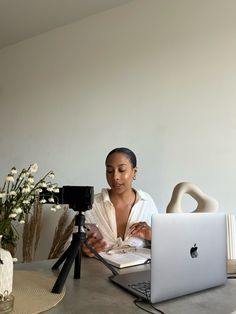 a woman sitting at a table with a laptop