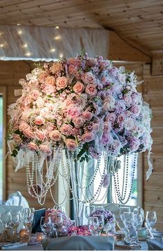 the centerpieces are adorned with pink flowers and pearls, along with crystalware