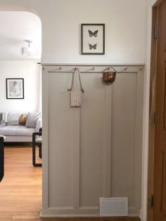 an entry way with white walls and wooden floors