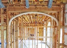 an arch in the middle of a building being built with wood framing and metal piping