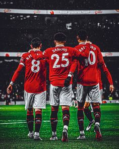 three soccer players in red and white uniforms are standing on the field with their arms around each other