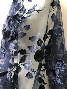 a blue and white dress with flowers on the front, along with black roses on the back