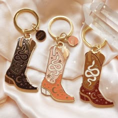 "Our cowgirl boot keychain is designed with the cosmic cowgirl in mind, featuring icons related to the moon goddess including a serpent & crescent moon.  Available in 3 colors: Blush Pink, Black & Brown.  Hard enamel keychain with gold tone detailing.   We are proud to be a member of 1% for the Planet 🌎 ▽. * Measures approx. 2 1/4\" high x 1 1/2\" wide * Features our original, Local Galaxy illustration * Hard enamel with soft, gold tone plating  * Packed on our signature backing card & cotton g Cowgirl Keychain, Cowboy Boot Keychain, Galaxy Illustration, Cowgirl Things, Cosmic Cowgirl, Cowgirl Stuff, Enamel Keychain, Cowgirl Accessories, Cowgirl Gifts