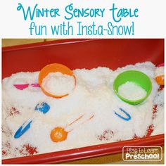 a red tray filled with white snow and two green bowls on top of it that says winter sensory table fun with insta - snow