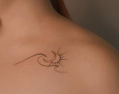 the back of a woman's shoulder with a sun and wave tattoo on it