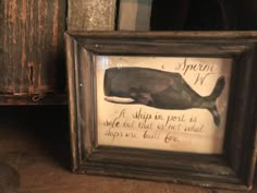 a framed whale is on display in a wooden frame with an old saying underneath it