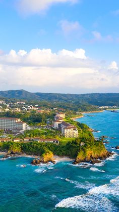 an aerial view of the ocean with hotels in the background