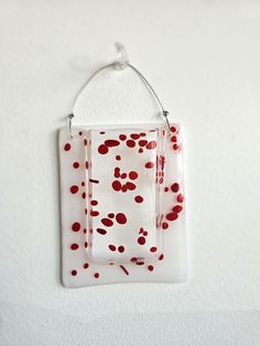 a red and white object hanging from a wall with a hook on it's side