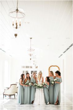 a group of women standing next to each other in front of a chandelier