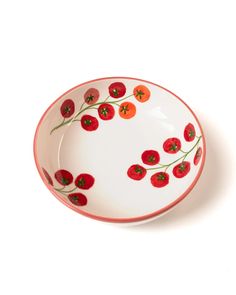 a white bowl with red flowers painted on the side and green stems in the middle