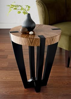 a wooden table with black metal legs and a vase on top