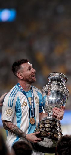 a man holding a trophy in front of his face and looking up at the sky