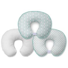 three white pillows with blue trims on the sides and one has a green dot pattern