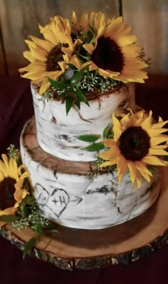 a three tiered cake with sunflowers on top