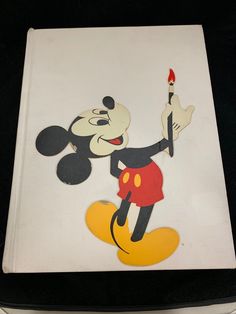 the mickey mouse is holding a paintbrush