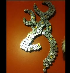 a lizard made out of bottle caps on a wall