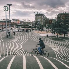 a man riding a bike down a street next to tall buildings