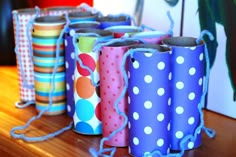 colorfully decorated toilet paper rolls sitting on top of a wooden table