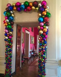 an archway decorated with christmas ornaments and balls