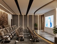 an empty auditorium with rows of chairs and a projector screen on the wall behind it