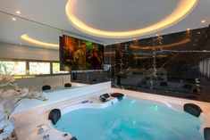 a large jacuzzi tub sitting inside of a bathroom next to a painting on the wall