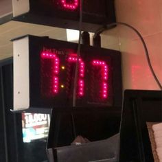 two red digital clocks hanging from the side of a wall