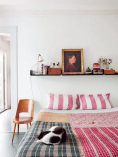 a cat laying on top of a bed in a bedroom