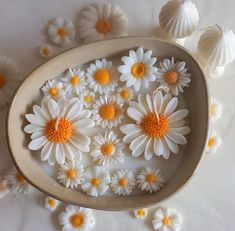 some white and yellow flowers in a bowl