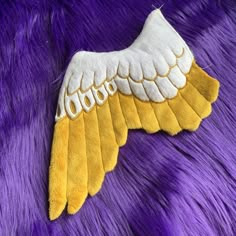 an image of a yellow and white wing on purple fur