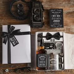 an old fashioned camera and other items are sitting on a table next to a gift box