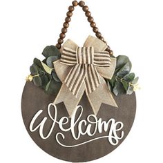 a welcome sign with a bow hanging from it's side on a white background