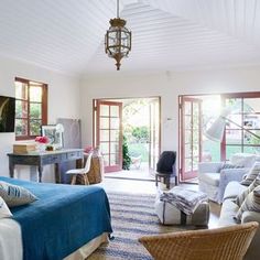 a living room filled with furniture and a blue blanket on top of a rug covered floor