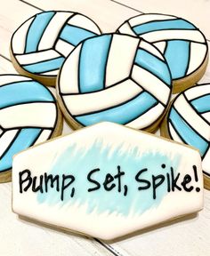 decorated cookies that say bump, set, spike on top of each other in blue and white