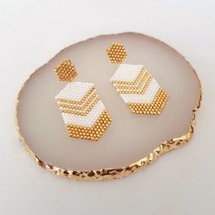 Modern hexagon earrings, with Miyuki beads in white and gold colors. Refined and very light to wear. Original and delicate stud earrings made with Miyuki beads and completely hand-woven by me. The base that holds the earring is in gold stainless steel. Features of the earrings are: Length: 4.8 cm Width: 2 cm Here you can see other designs of white, gold and silver earrings: https://www.etsy.com/shop/AQBijouterie?ref=seller-platform-mcnav&section_id=34429251   It will be a pleasure to answer you Gold And Silver Earrings, Hexagon Earrings, Schmuck Gold, Native American Crafts, Earrings Summer, Summer Earrings, Summer Earring, Gold Stud Earrings, Miyuki Beads