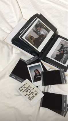 several polaroid photos are laying on top of a white sheet with black border around them