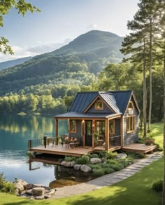 a small house on the water with mountains in the backgroung and trees