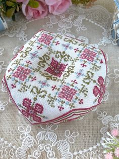 a close up of a piece of cloth on a table with flowers in the background