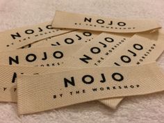 four nojo labels are laid out on a white towel with the words'nojo'written across them