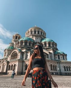 a woman standing in front of a large building