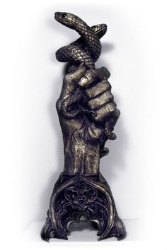 a statue of a hand holding a snake