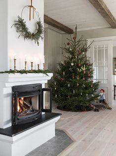 a living room with a christmas tree and fireplace