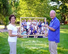 a man and woman standing in front of a photo frame with an image on it