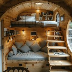 the interior of a tiny cabin with stairs leading up to it's loft bed