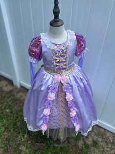 Transform your little one into a fairy tale princess with this enchanting lilac dress, perfect for special occasions and dress-up play. Crafted with love and meticulous attention to detail, this dress is sure to make dreams come true. ✨ **Features 🌸 **Elegant Design Lavish lilac satin fabric adorned with delicate lace and floral accents. 💫 **Sparkling Details Glittery sequin puff sleeves add a touch of magical sparkle. 🎀 **Lace-Up Bodice Intricate lace-up front with pearl embellishments for a Lavender Fitted Princess Dress For Dress-up, Lavender Princess Dress For Dress-up, Lavender Princess Dress For Dress-up Occasions, Lavender Tulle Princess Dress For Dress-up, Lavender Tulle Dress For Dress-up, Lavender Tulle Dress For Dress-up Occasions, Princess Style Lavender Fairy Dress For Party, Lavender Princess Dress For Wedding, Purple Tulle Fairy Dress For Dress-up