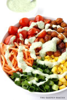 a colorful salad with dressing in a white bowl