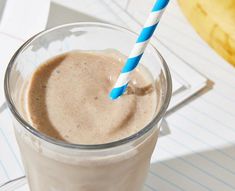 a smoothie in a glass with a blue and white striped straw