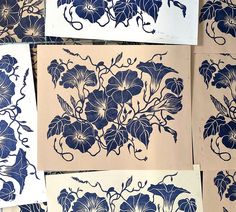 several blue and white flowers are on paper with black ink in the middle, along with other drawings