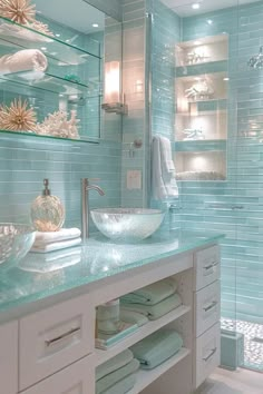 a bathroom with blue glass tile walls and white counter tops, along with a vessel sink